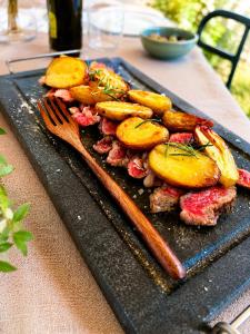a plate of food with vegetables and a fork on a table at Il Cerchio delle Streghe Country House al Podere Casella in Castiglione dʼOrcia
