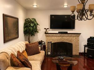 a living room with a couch and a fireplace with a tv at Luxury Pre-War Townhouse Bronx 5BR in University Heights