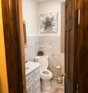 a bathroom with a white toilet and a sink at Luxury Pre-War Townhouse Bronx 5BR in University Heights +21 photos