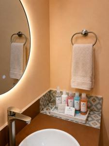 ein Badezimmer mit Waschbecken, Spiegel und Handtüchern in der Unterkunft Hotel Barrio Boutique in Monterrey