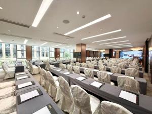 a conference room with rows of chairs and tables at 厦门伟尔酒店Xiamen Well Hotel in Gaolin +70 photos