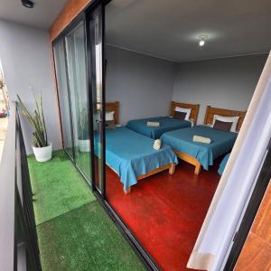 two beds in a room with a balcony at Lima Airport Hostel - FREE AIRPORT PICK UP in Lima
