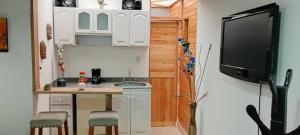 a small kitchen with a small table and a tv at Villa chava in Ibagué