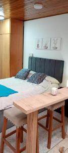 a bedroom with a bed and a wooden table at Villa chava in Ibagué