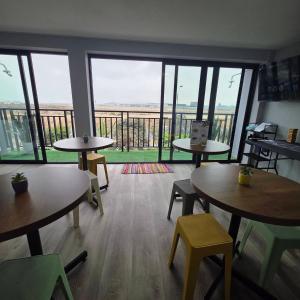 a room with tables and chairs and a large window at Lima Airport Hostel - FREE AIRPORT PICK UP in Lima