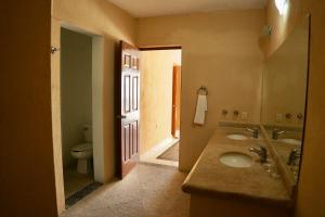 a bathroom with two sinks and a toilet and a door at Rincon Frente al mar in Acapulco +3 photos