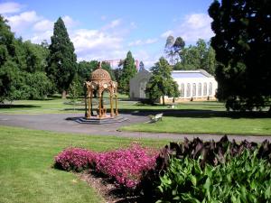a gazebo in the middle of a park with flowers at Parklane Motel in Launceston