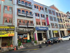 a building on a street with cars parked in front of it at One World Hotel in Kulai
