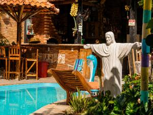 a statue of a christ redeemer next to a pool at Pousada Mirante Pôr do Sol in Maricá