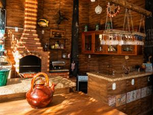 a kitchen with a tea kettle on a table with a fireplace at Pousada Mirante Pôr do Sol in Maricá +194 photos