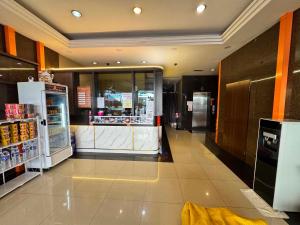 a grocery store aisle with a counter and a refrigerator at One World Hotel in Kulai +7 photos