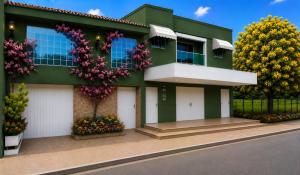 a green house with flowers in front of it at Apartamento São Pedro SP in São Pedro