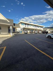 a parking lot with cars parked in front of a building at Coastline Motel Kamloops in Kamloops