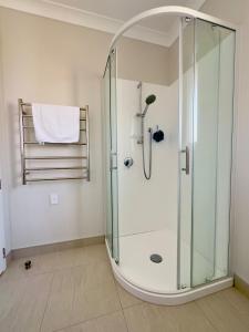 a shower with a glass enclosure in a bathroom at Sweet Serendipity in Tauranga +13 photos