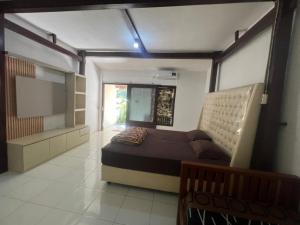 a bedroom with a bed and a tv in it at Tiara Homestay Banyuwangi Near train Station in Banyuwangi