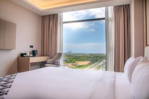 a hotel room with a bed and a large window at The MAJULAN Hotel in Kota Kinabalu