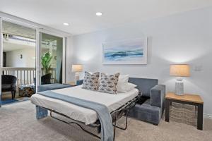 a bedroom with a bed and a chair at G207 - Surfer's Hideaway in Oceanside +50 photos