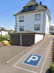 a parking lot with a parking sign in front of a house at Ferienwohnung Saarburg in Saarburg