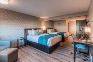 a hotel room with two beds and a desk at The Hotel Y, a Dazzler Select by Wyndham in Yakima
