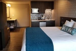 a hotel room with a bed and a kitchen at The Hotel Y, a Dazzler Select by Wyndham in Yakima +31 photos