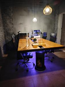 an office with a wooden table with chairs and a laptop at Suíte cine centro in Garanhuns