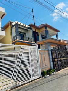 a house with a white fence in front of it at KiGALI CLASSIC LODGE in Kigali