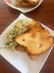 a plate of food with toast and rice on a table at KiGALI CLASSIC LODGE in Kigali