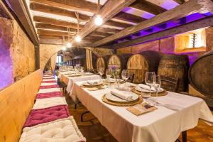 una fila de mesas en una habitación con barriles de vino en Masia Can Canyes & Spa, en Sant Llorenç d'Hortons