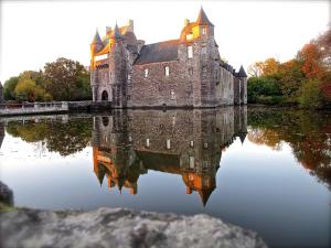 um reflexo de castelos na água de um castelo em Kerarz - Chambre d'hôtes em Mauron