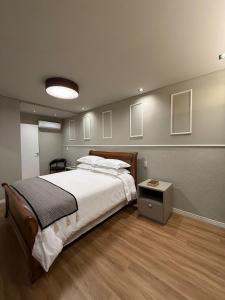 a bedroom with a large bed and a table at Apartamento 204 Cheia de Graca in Divinópolis
