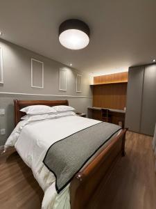 a bedroom with a large bed and a large light at Apartamento 204 Cheia de Graca in Divinópolis +15 photos