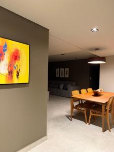 a dining room with a wooden table and chairs at Apartamento 204 Cheia de Graca in Divinópolis