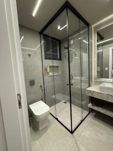 a bathroom with a shower and a toilet and a sink at Apartamento 204 Cheia de Graca in Divinópolis