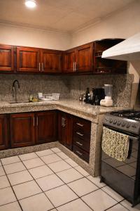a kitchen with wooden cabinets and a stove at Suite Colonial Patrimonio UNESCO Centro Histórico Cuenca in Cuenca