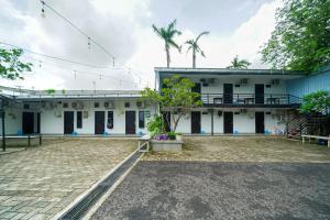a building with a courtyard in front of it at JM Tuparev Mitra RedDoorz in Karawang
