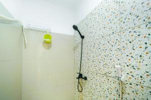 a shower with a shower head in a bathroom at JM Tuparev Mitra RedDoorz in Karawang +21 photos