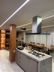 a kitchen and dining room with a stove top at Apartamento 204 Cheia de Graca in Divinópolis