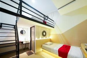 a bedroom with a bunk bed and a ladder at JM Tuparev Mitra RedDoorz in Karawang