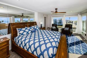 a bedroom with a blue and white bed and windows at B301 - Seaclusion - On-the-Sand in Oceanside +72 photos