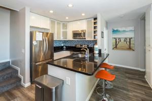 a kitchen with a sink and a refrigerator at B301 - Seaclusion - On-the-Sand in Oceanside