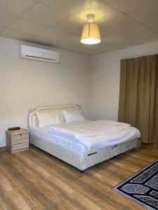 ein Schlafzimmer mit einem weißen Bett und einer Lampe in der Unterkunft Sand Camp Oman in Badīyah + 66 Fotos