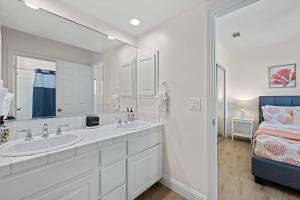 a white bathroom with two sinks and a bed at Sunset On The Strand in Oceanside +68 photos