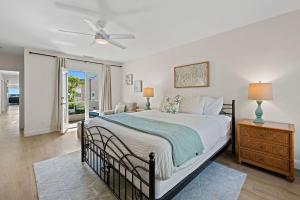 a bedroom with a large bed with a ceiling fan at Sunset On The Strand in Oceanside