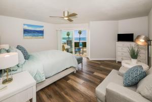 a bedroom with a bed and a couch and a television at Pacifica Strand Unit 15 in Oceanside
