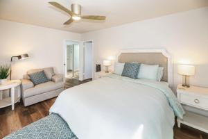 a white bedroom with a bed and a couch at Pacifica Strand Unit 15 in Oceanside