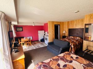 a hotel room with two beds and a chair and a table at Wheel Inn Motel in Assiniboia