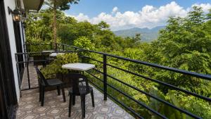 a balcony with a table and chairs and mountains at Mabini Sky View in Cebu City