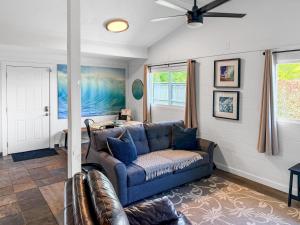 a living room with a couch and a ceiling fan at Coral Wave Cottage in Waialua