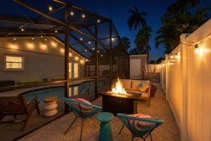 a backyard with a pool and chairs and a fire pit at Sunwashed Stone Villa with Heated Pool, Hot Tub & Mini Golf in Bradenton