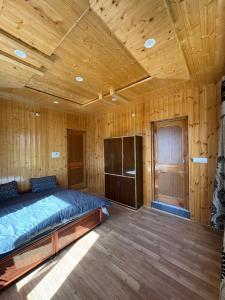 a bedroom with a bed in a wooden room at Shubham homestay in Sissu +2 photos